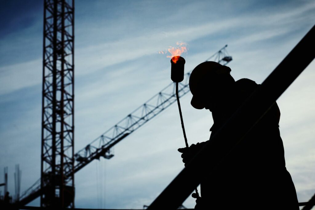 Silhouette image of an engineer carrying a torch