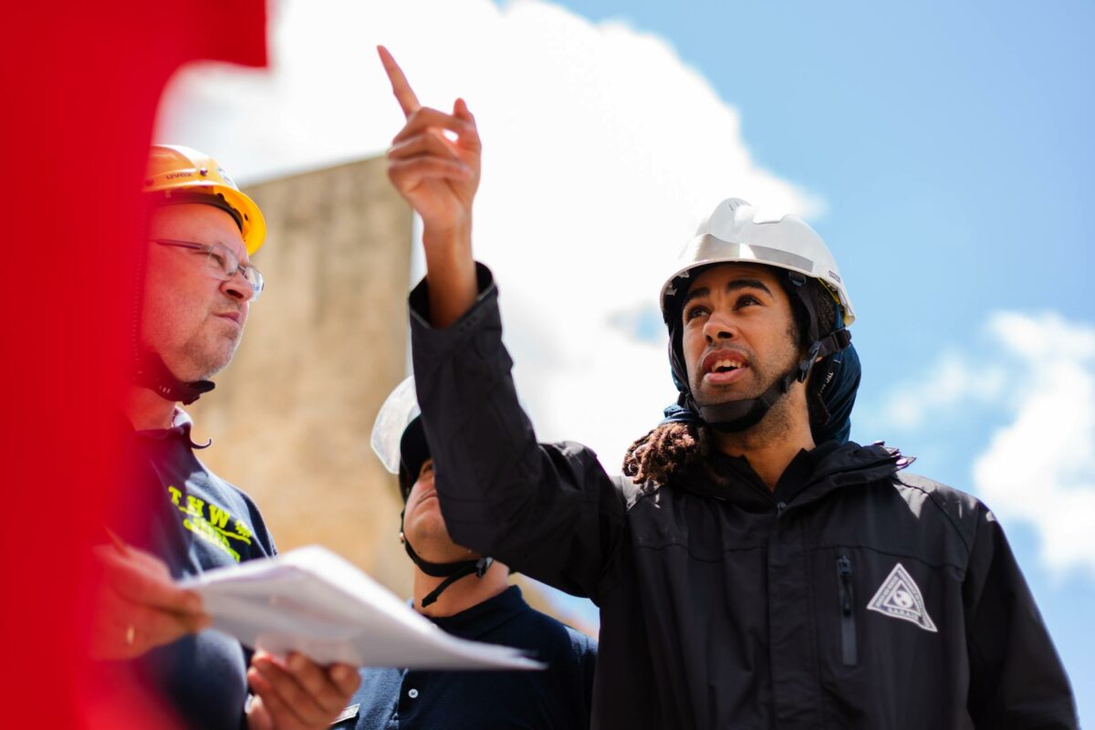 An engineer pointing upwards in discussion