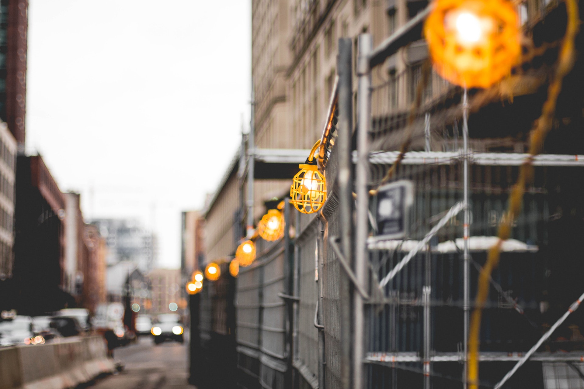 Selective focus photo of lit lamps on a construction perimeter